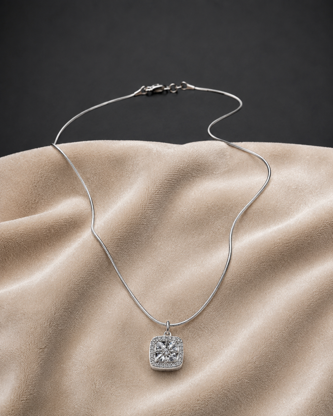 Classic Silver Halo CZ Pendant Necklace on sleek snake chain displayed on beige fabric