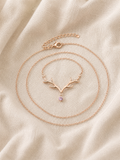 Dainty Rose Gold Antler Necklace with pink crystal drop displayed on cream linen fabric