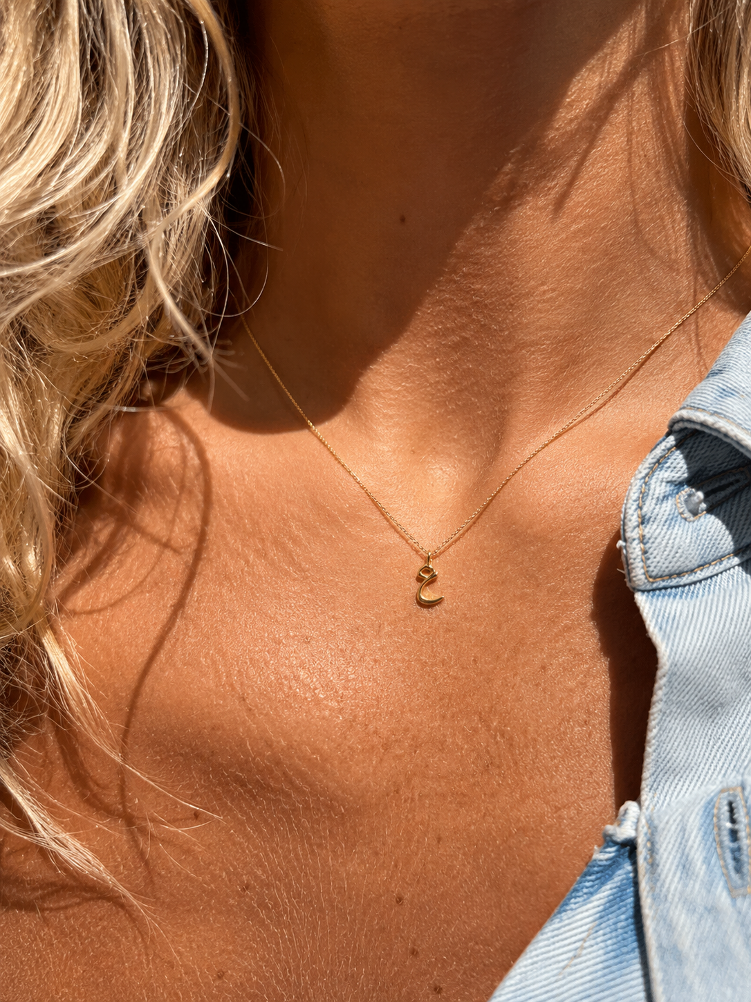 Dainty Gold Crescent Moon Necklace worn on collarbone